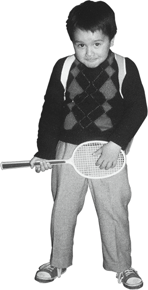 Image of Pedro Rodrigues (Treze413) when he was a 5 years old child. He is hold a racket simulating he is playing a guitar with a cheeky grin in his face and a school bag in his back. Picture taken in 1987